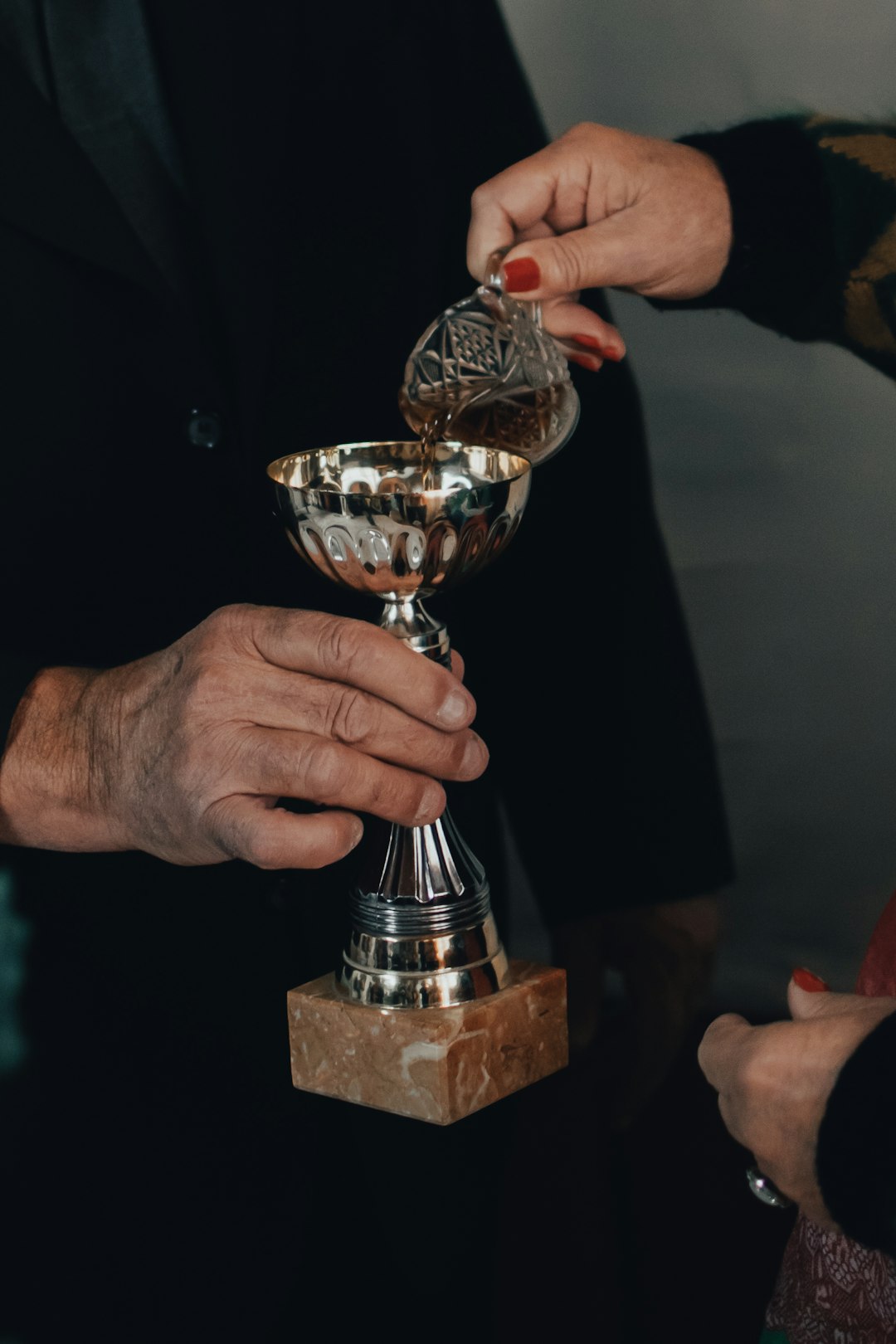 person holding gold trophy on brown wooden table wildcatters championship trophy celebration