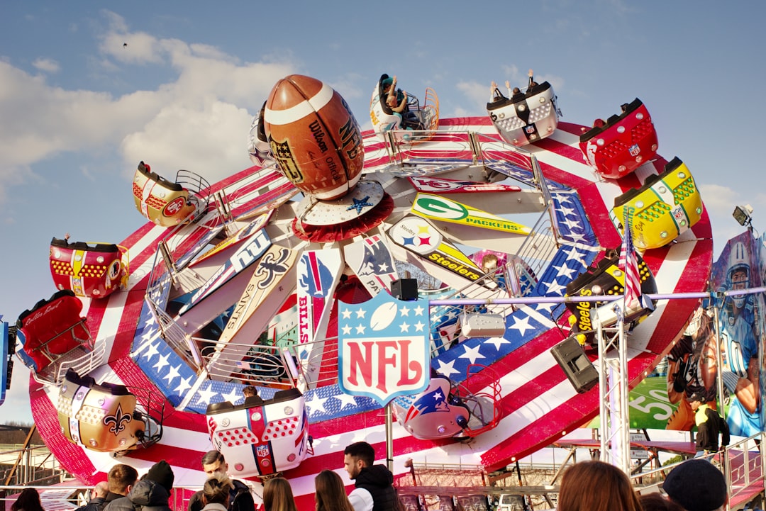 a carnival ride with people standing around it roblox football, nfl team celebration, touchdown dance, game win