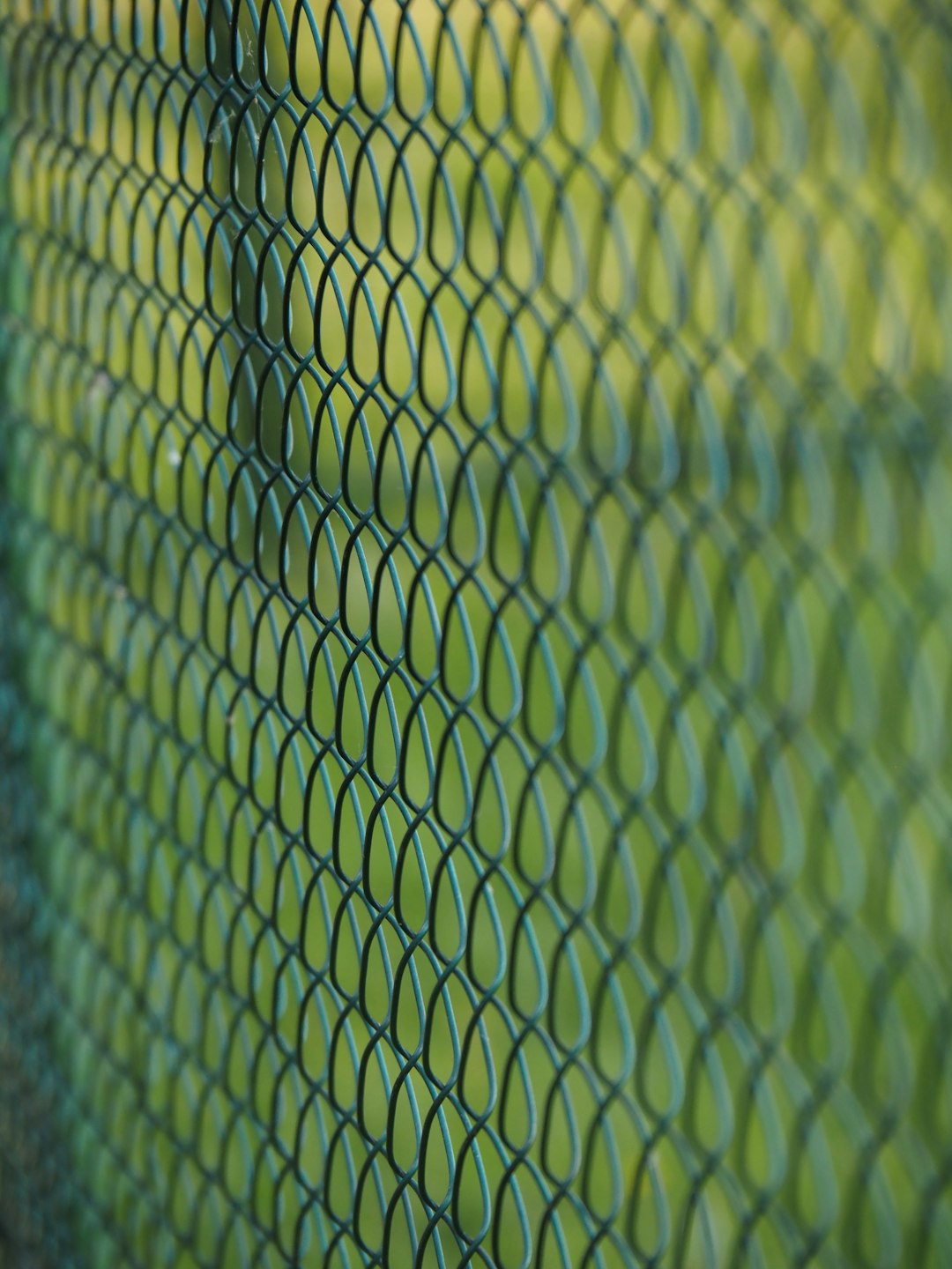 a close up view of a green fence outdoor court resurfacing pickleball acrylic lines