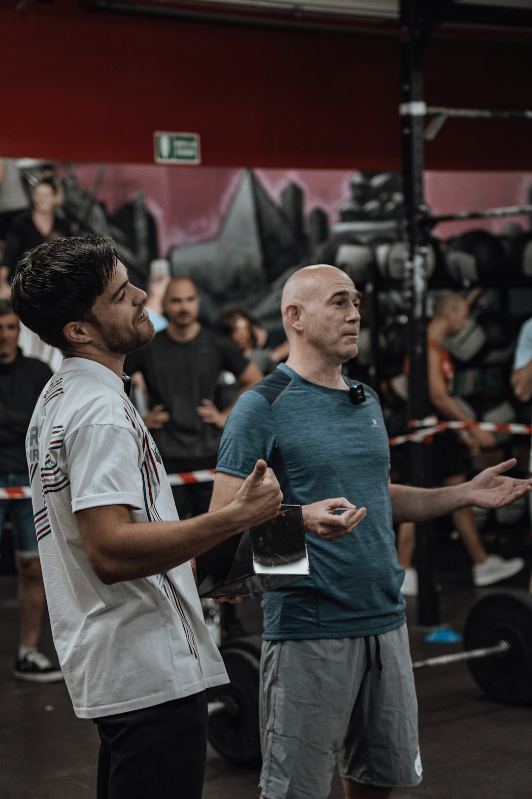 a couple of men standing next to each other coach athlete training session, gym consultation, athlete evaluation