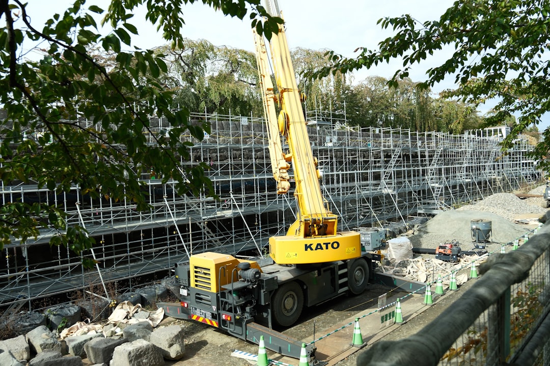 A crane that is sitting in the dirt construction of tennis court grading resurfacing crew