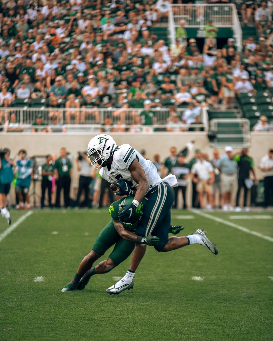 A football player is running with the ball linebacker stance tackle football game action