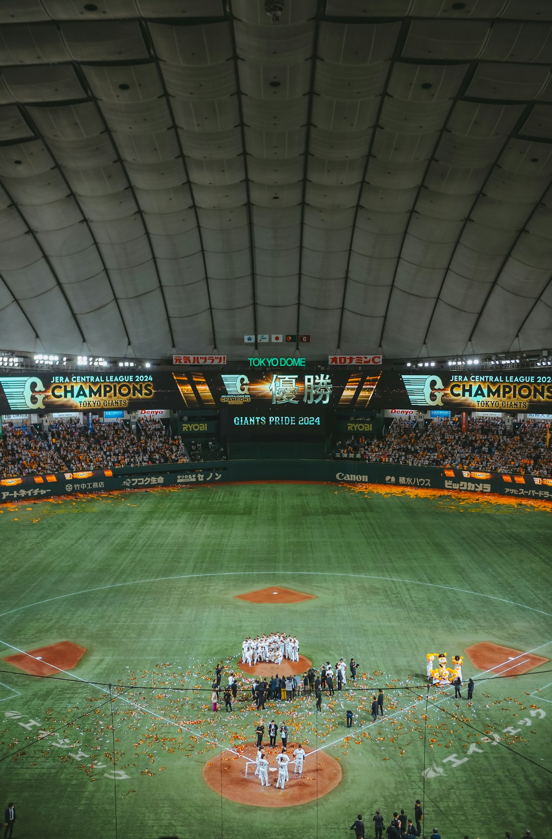 A group of people standing on top of a baseball field tokyo dome, yomiuri giants, japanese baseball fans