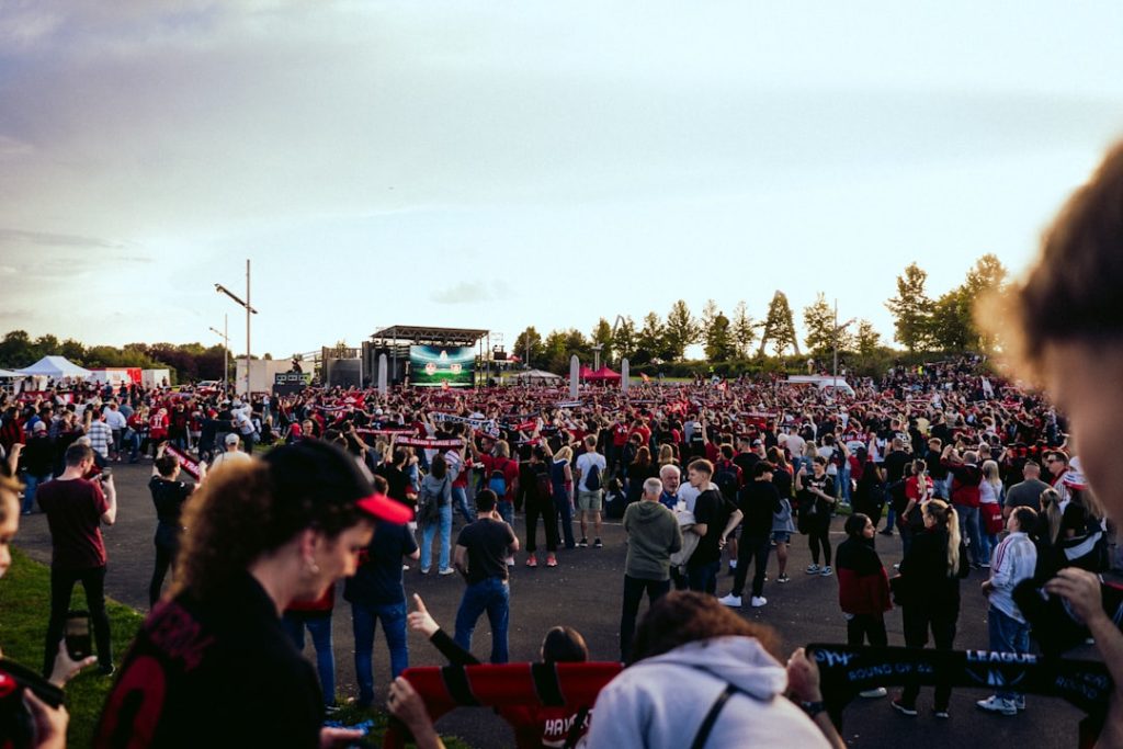 A large crowd of people standing in a parking lot hawaii football, stanford matchup, college football crowd
