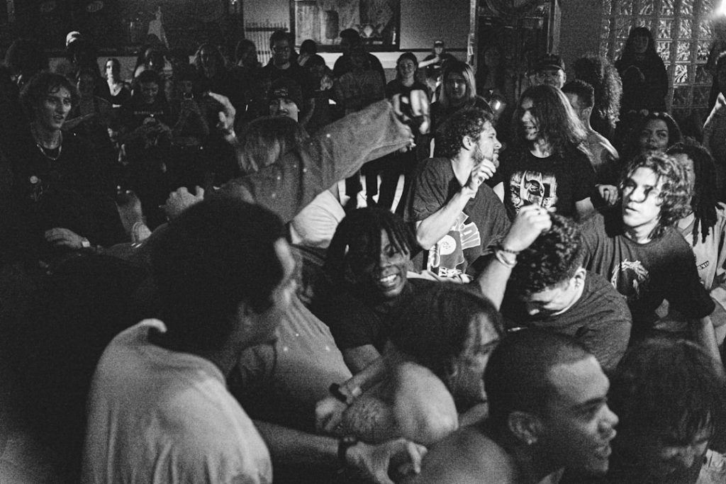 a large group of people sitting in a room jalen milroe, alabama quarterback, touchdown celebration