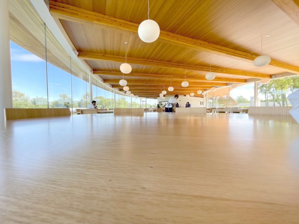 a large room with a wooden ceiling and white walls indoor gym flooring hardwood rubber court