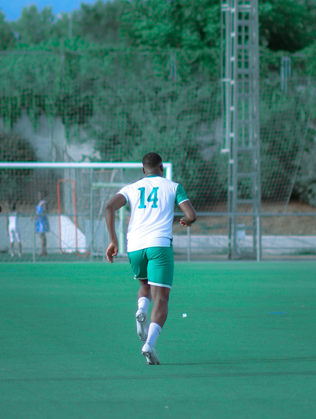 a man in a white jersey running on a grass field calleri goal celebration bragantino defender