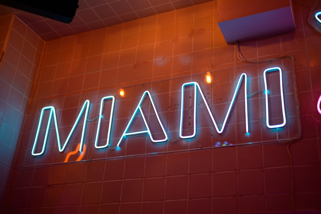 A neon sign on the wall of a restaurant miami fans, heat jersey, tailgate party