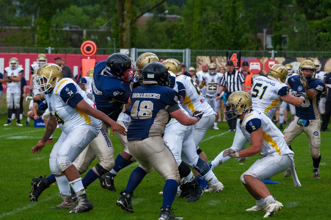 American football players in action during a game. football linebacker blitz quarterback tackle