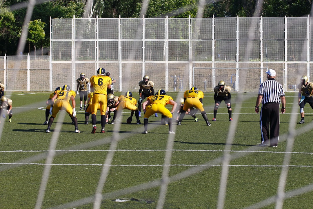 football game on outdoor green field during daytime football interception defense touchdown celebration