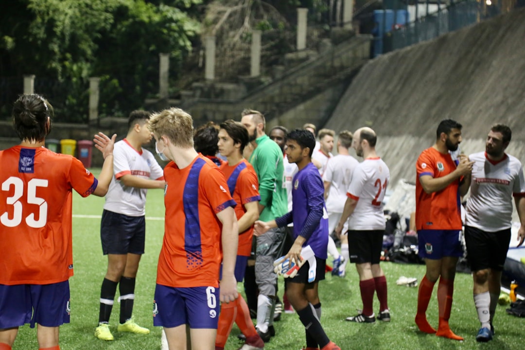 group of people in green and orange soccer jersey shirt football tactics board, formations, managers talking