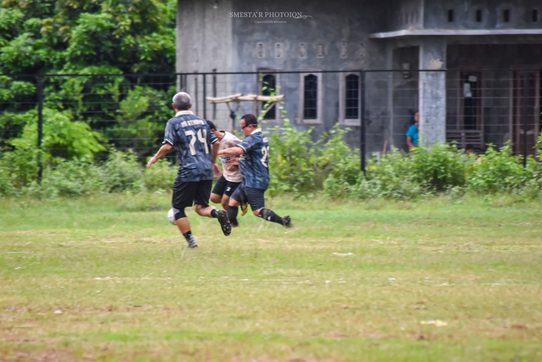 Men playing soccer on a grassy field dante moore, ucla quarterback, passing action