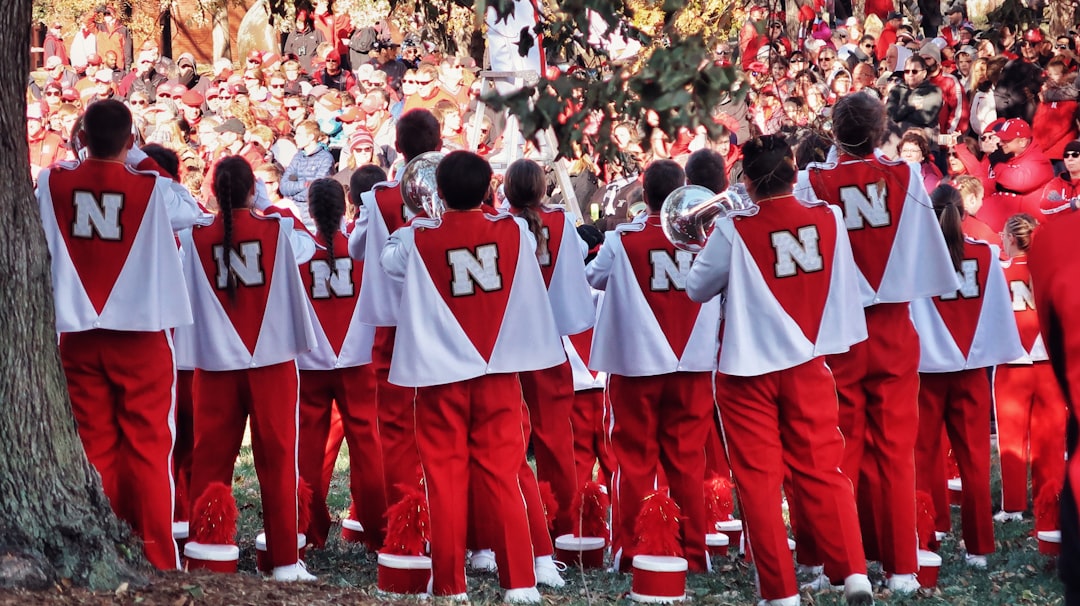 people in red and white uniform standing on green grass field during daytime nebraska jersey, game worn, football tradition