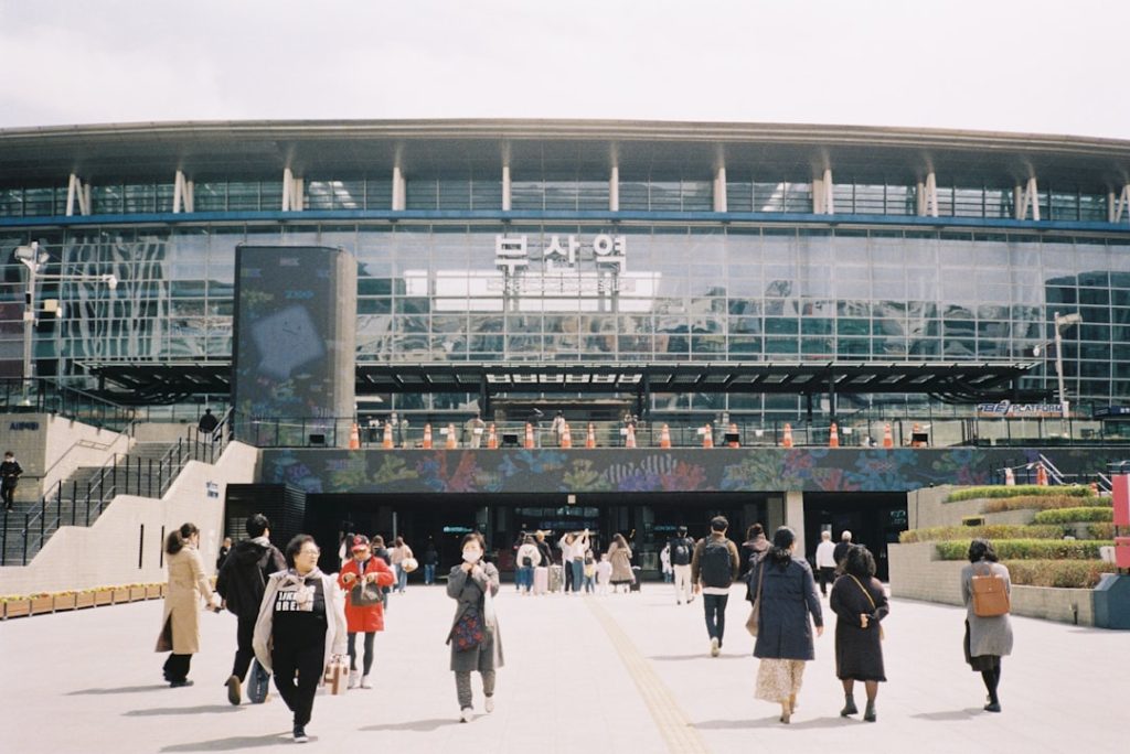 People walk towards a modern train station. tokyo dome, yomiuri giants, japanese baseball fans