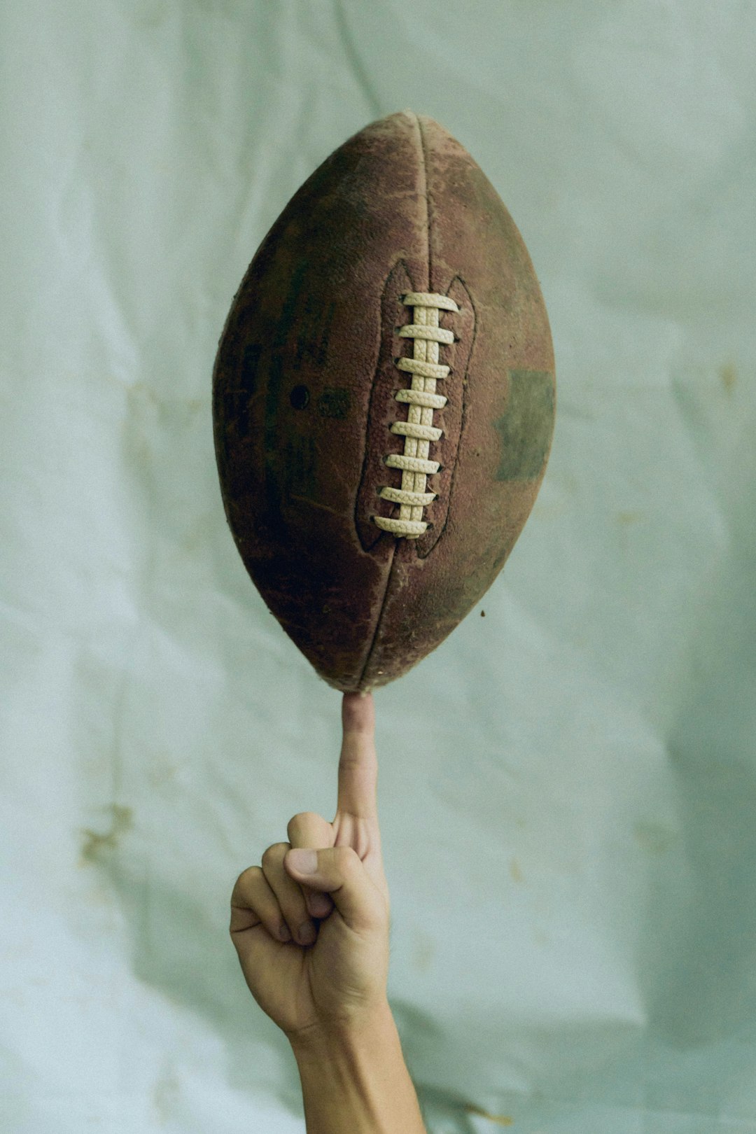 person holding brown football ball modern tight end, football catch, nfl stars