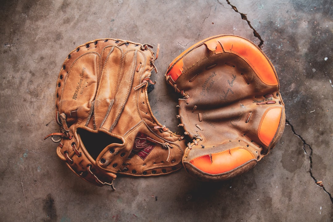 a baseball glove laying on the ground softball construction, inner core, leather seams