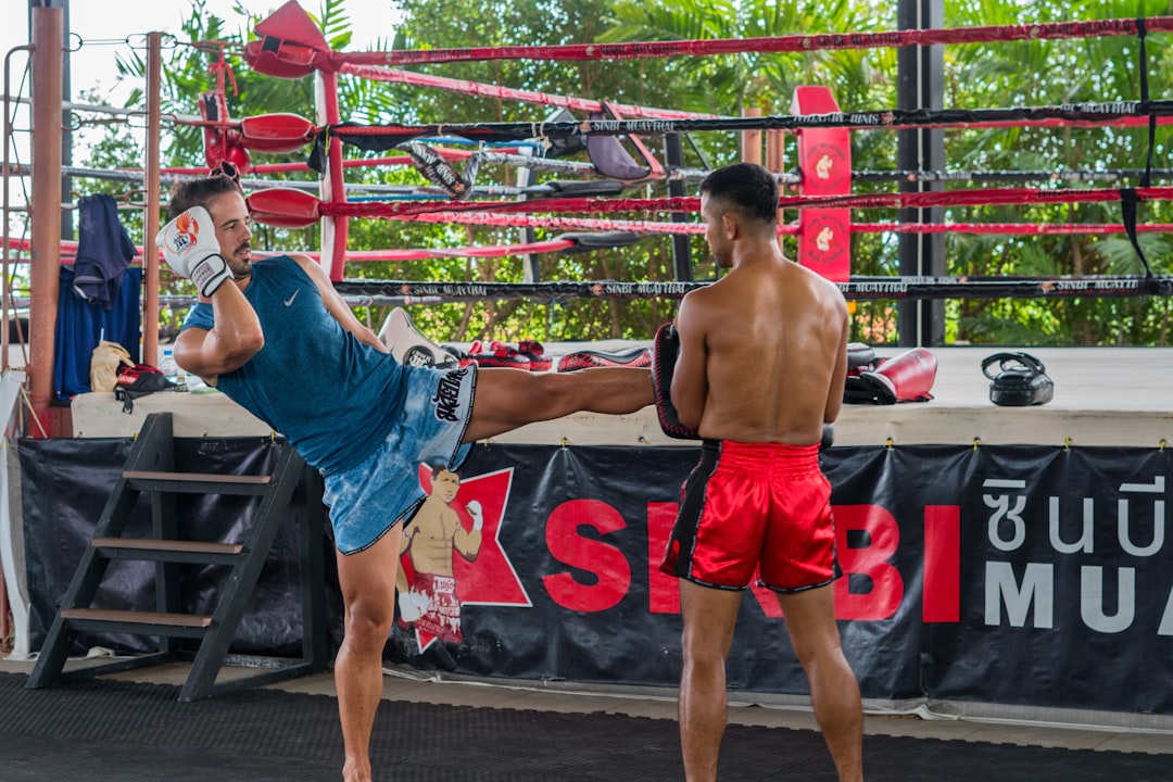 a couple of men standing next to each other in a boxing ring muay thai belt system, western gym, student testing