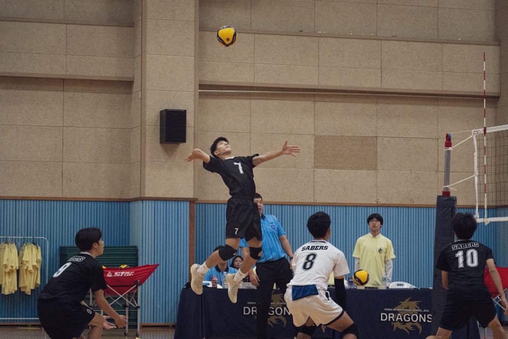 A group of men playing a game of volleyball volleyball setter jump set concentration
