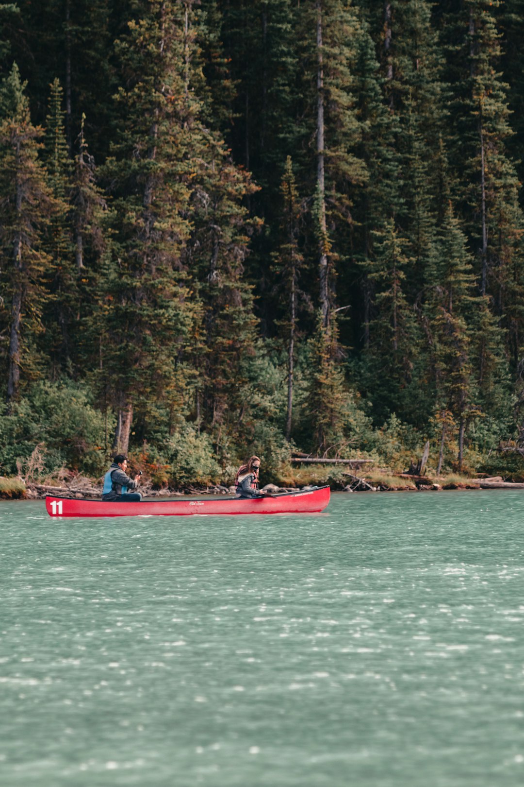 a group of people in a red boat on a river kayaking, paddling, nature, full body workout
