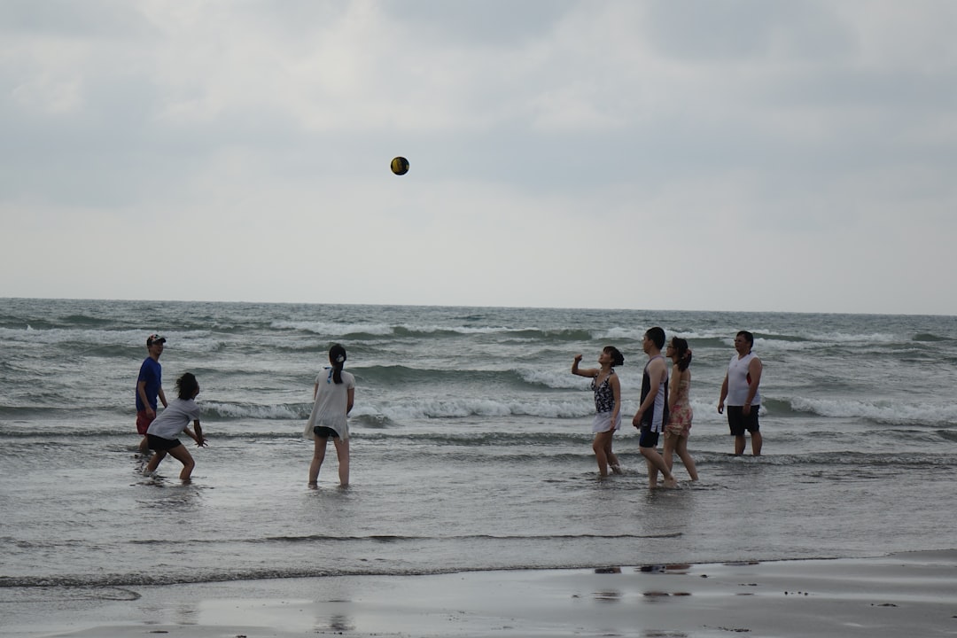 a group of people playing volleyball on the beach youth volleyball, kids playing volleyball, junior sports
