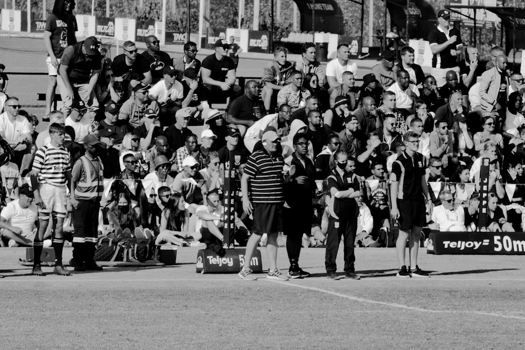 a group of people standing on a street with a crowd watching nwsl players celebration field fans