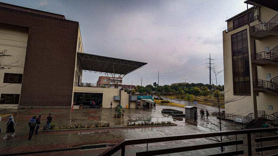a group of people standing outside of a building football weather delay rain thunderstorm stadium
