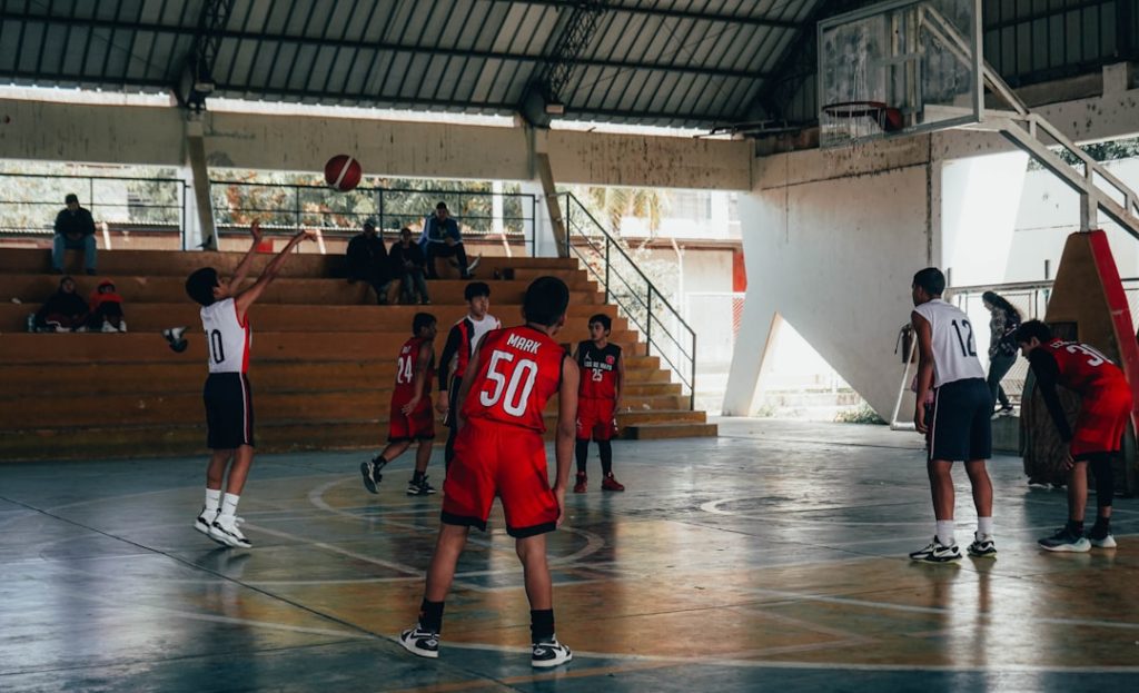 A group of young men playing a game of basketball volleyball team indoor court uniforms