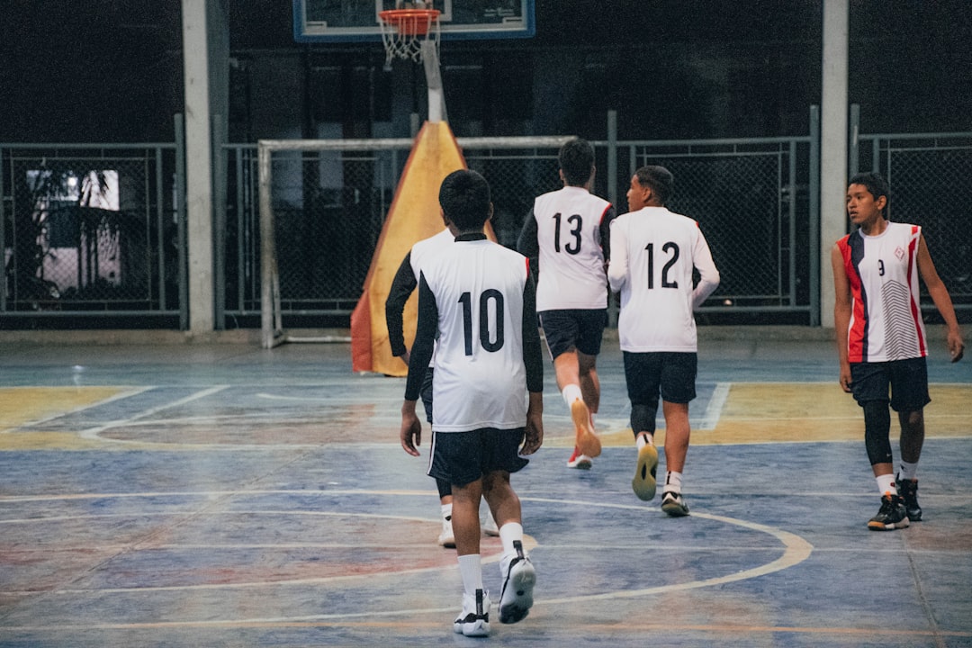A group of young men playing a game of basketball volleyball team indoor court uniforms