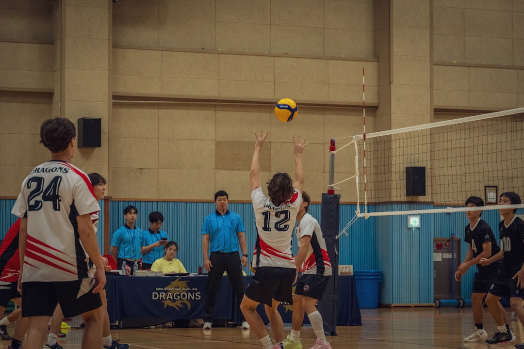 A group of young men playing a game of volleyball volleyball setter jump set concentration