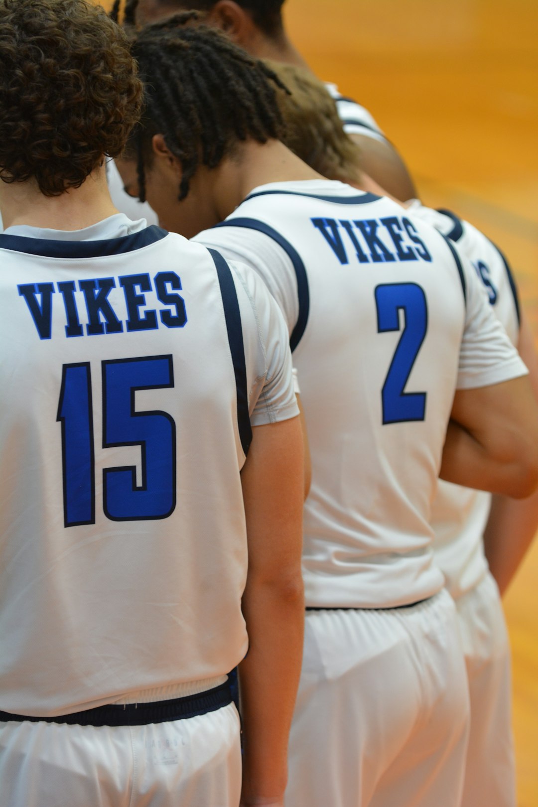 A group of young men standing next to each other on a basketball court volleyball team indoor court uniforms