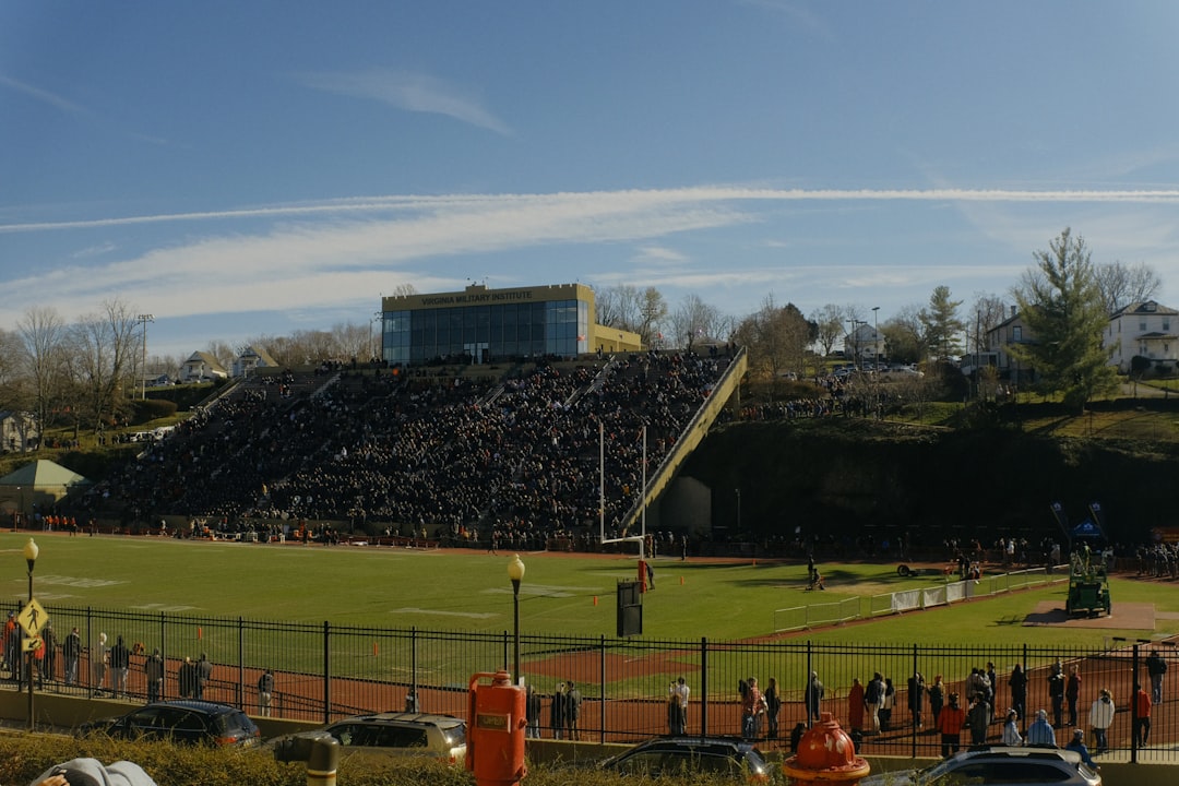 a large crowd of people at a football field grinnell college fans cheering football game