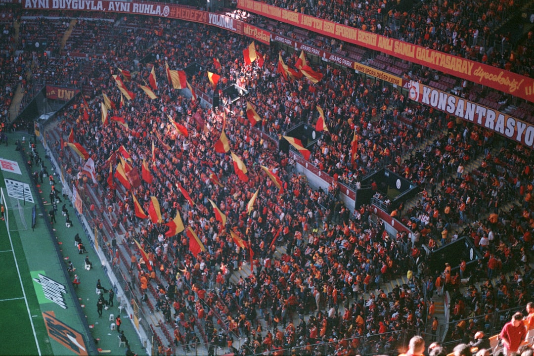A large crowd of people at a soccer game soccer fans, intense match, stadium atmosphere, rival team flags