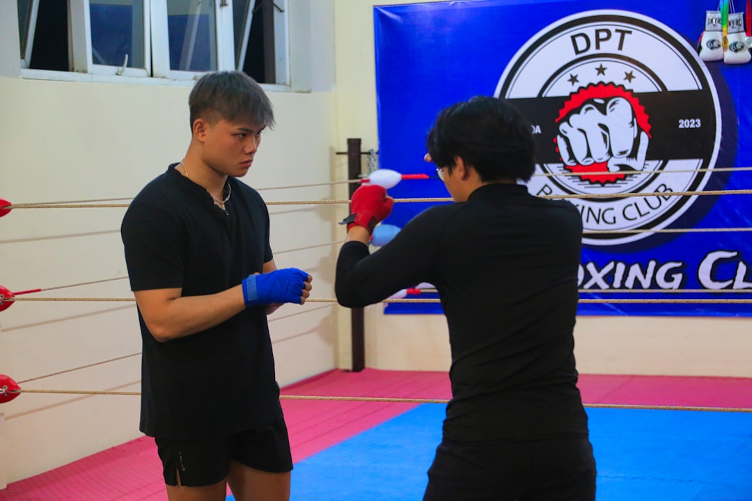 a man and a woman standing in a boxing ring muay thai coach, pad work, martial arts training