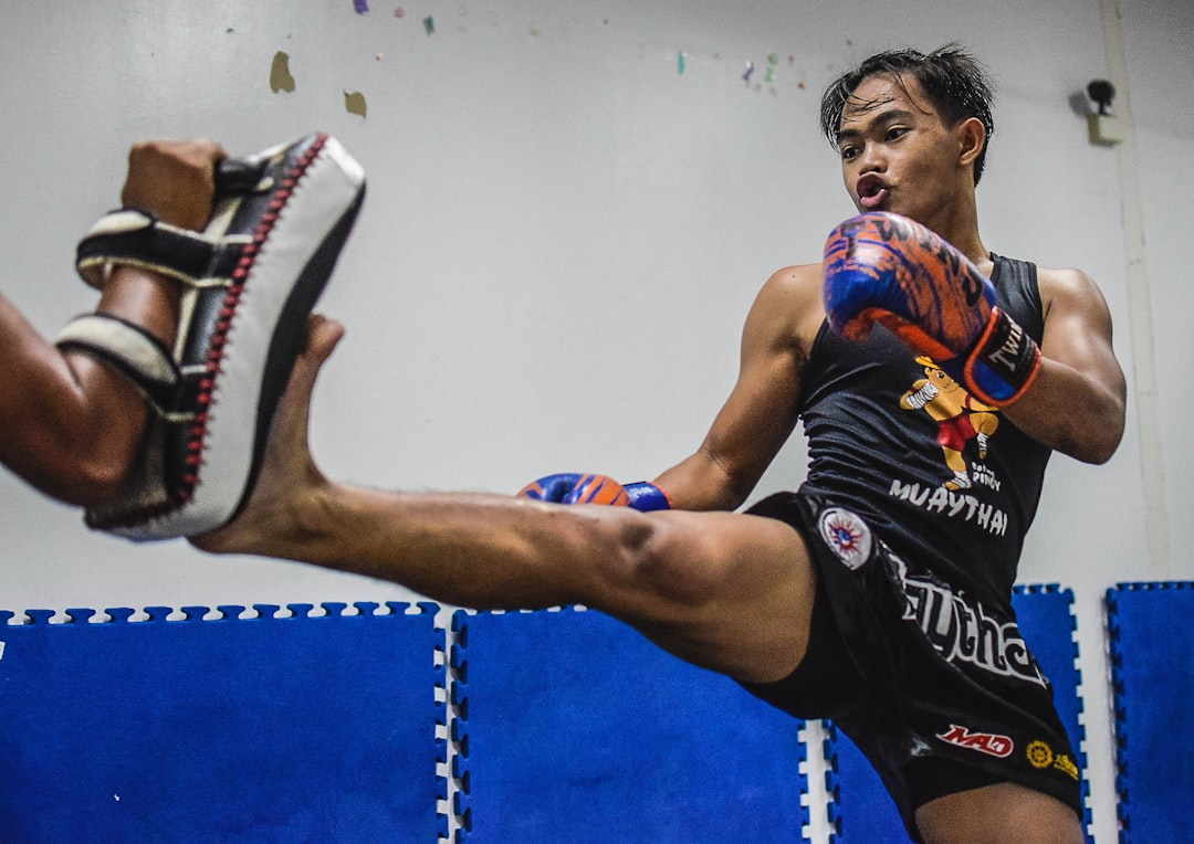 a man kicking a ball in a gym famous fighters, buakaw petrosyan, muay thai kickboxing