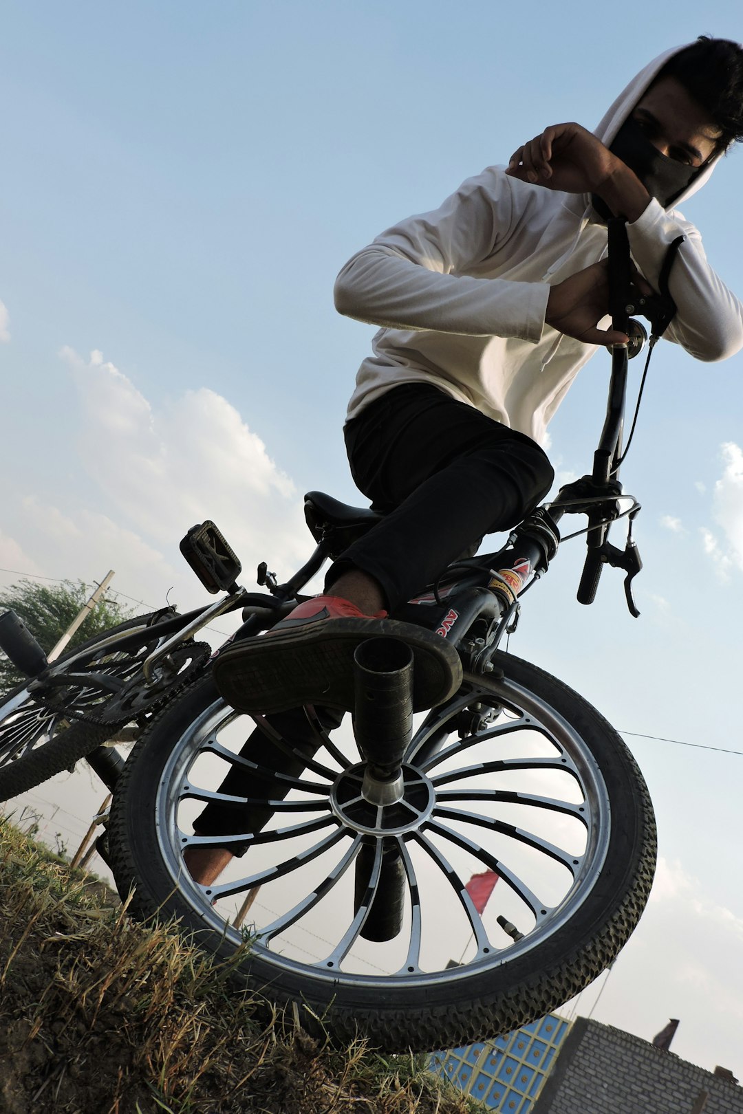 a man riding a bike on top of a grass covered hillside bmx bike parts wheels frame seat