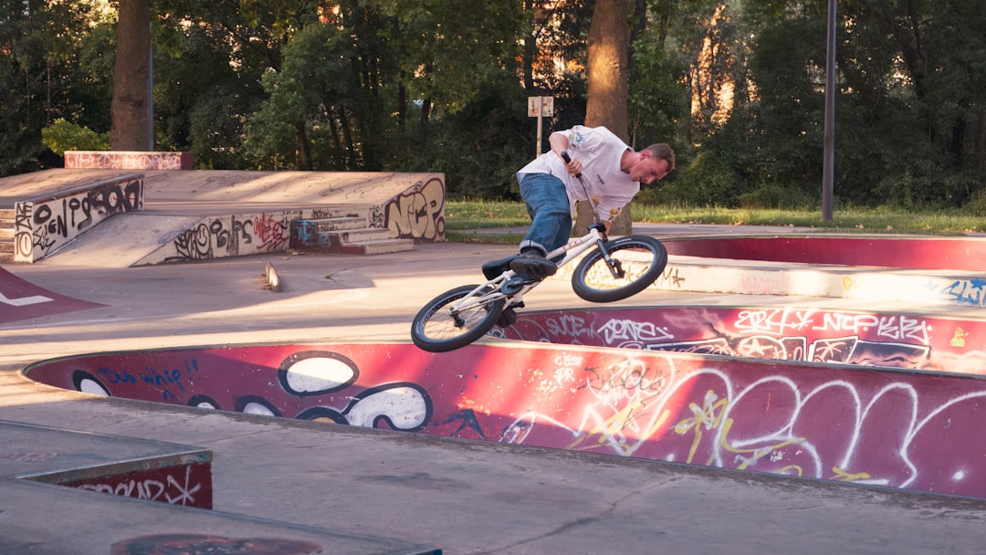 A man riding a skateboard up the side of a ramp bmx tailwhip, skateboard kickflip, progression