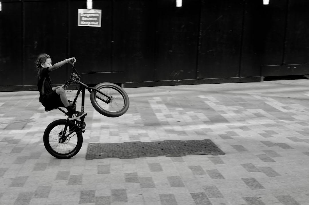 a person on a bike doing a trick in the air bmx tricks, freestyle riding, urban setting