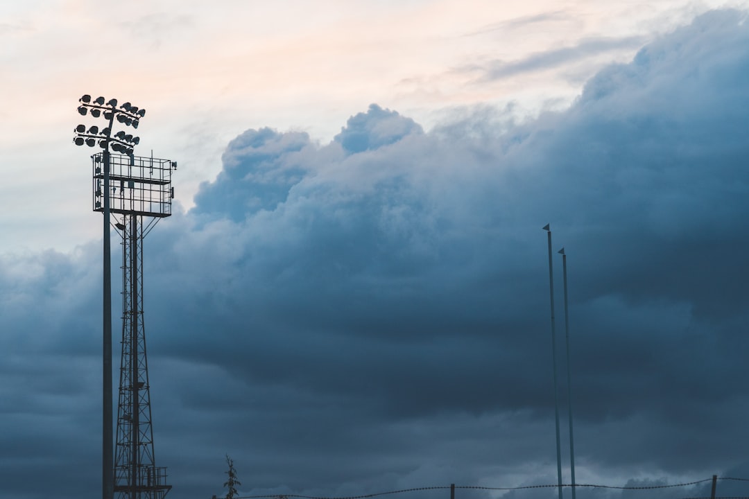 black metal tower under white clouds football weather delay rain thunderstorm stadium