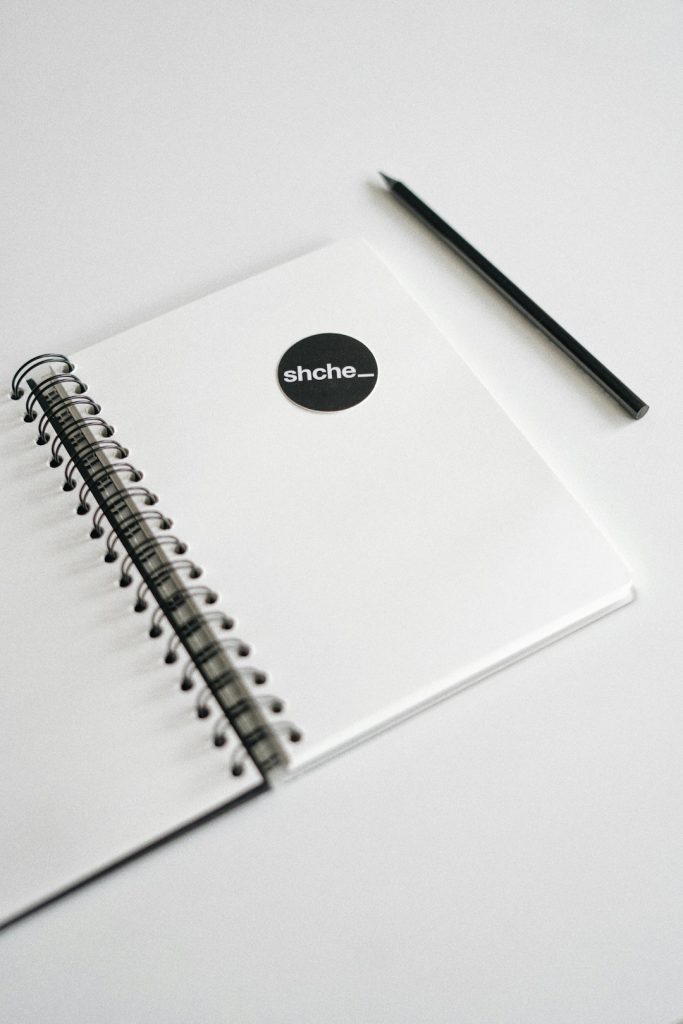 black pen on white spiral notebook startup logo, saas product, bootstrap, mvp phase