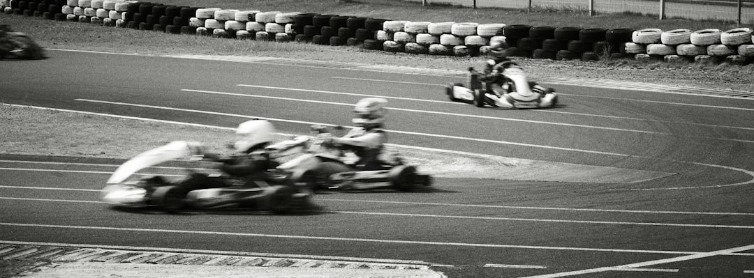 Go karts racing on a track with barriers. indycar oval speed race, formula 1 grand prix track