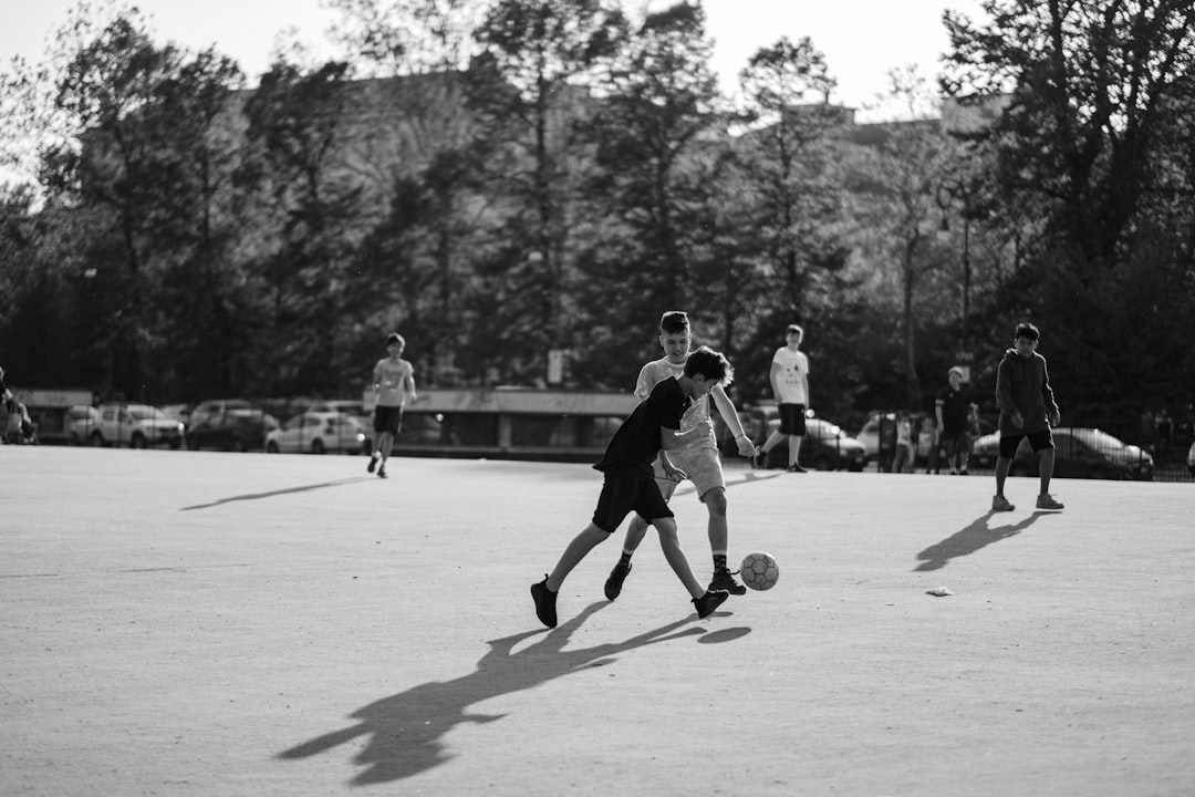 grayscale photo of group of man playing soccer on field youth lacrosse, practice session, soft balls