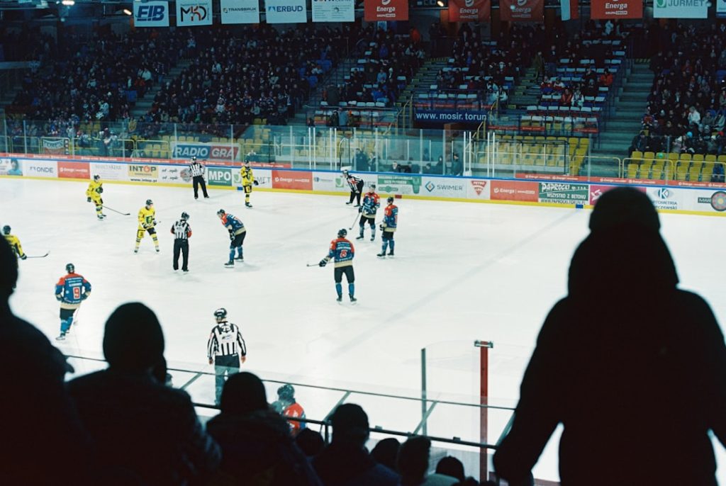 Hockey players and referees are on the ice. espn plus, nhl streaming, hockey fans