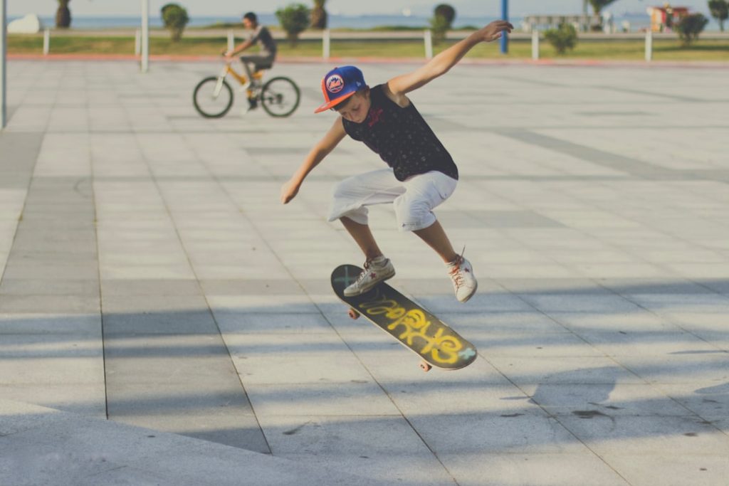 man in blue t shirt and white shorts riding on skateboard during daytime bmx rider, skateboarder, skatepark
