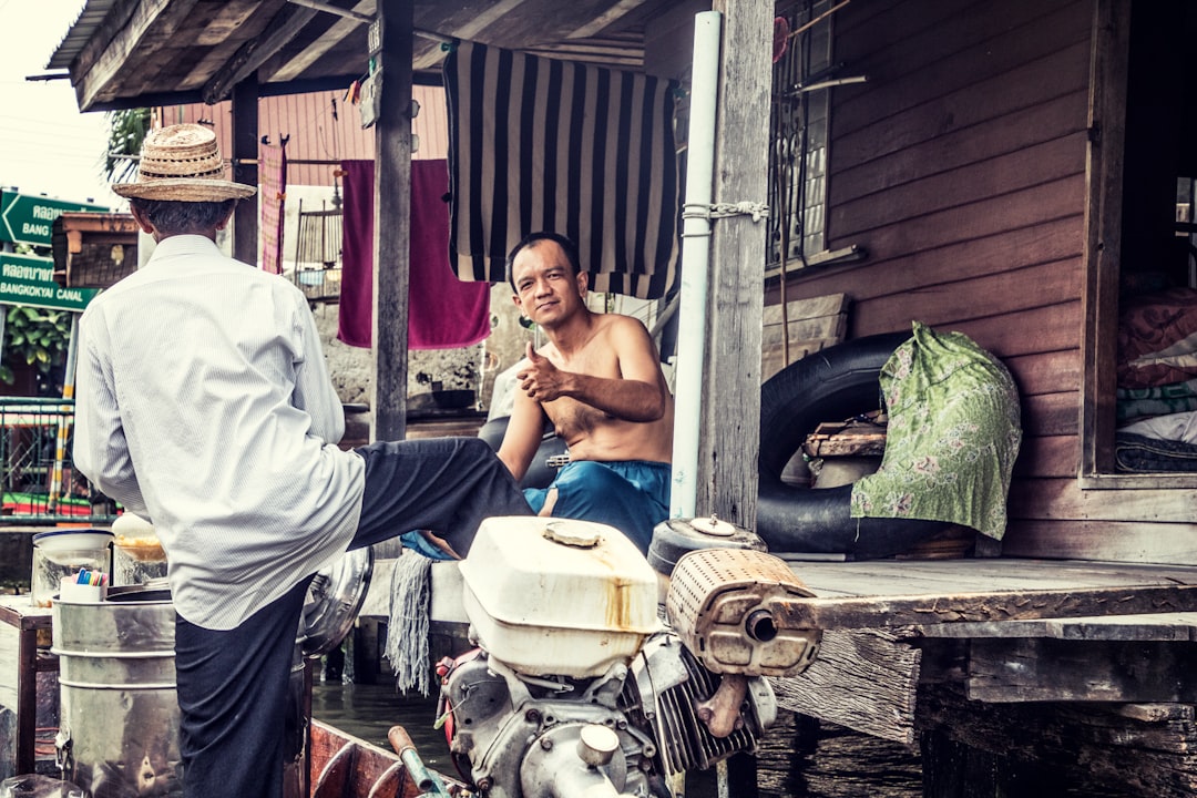 man in white top standing beside topless person muay thai, thailand, traditional fight