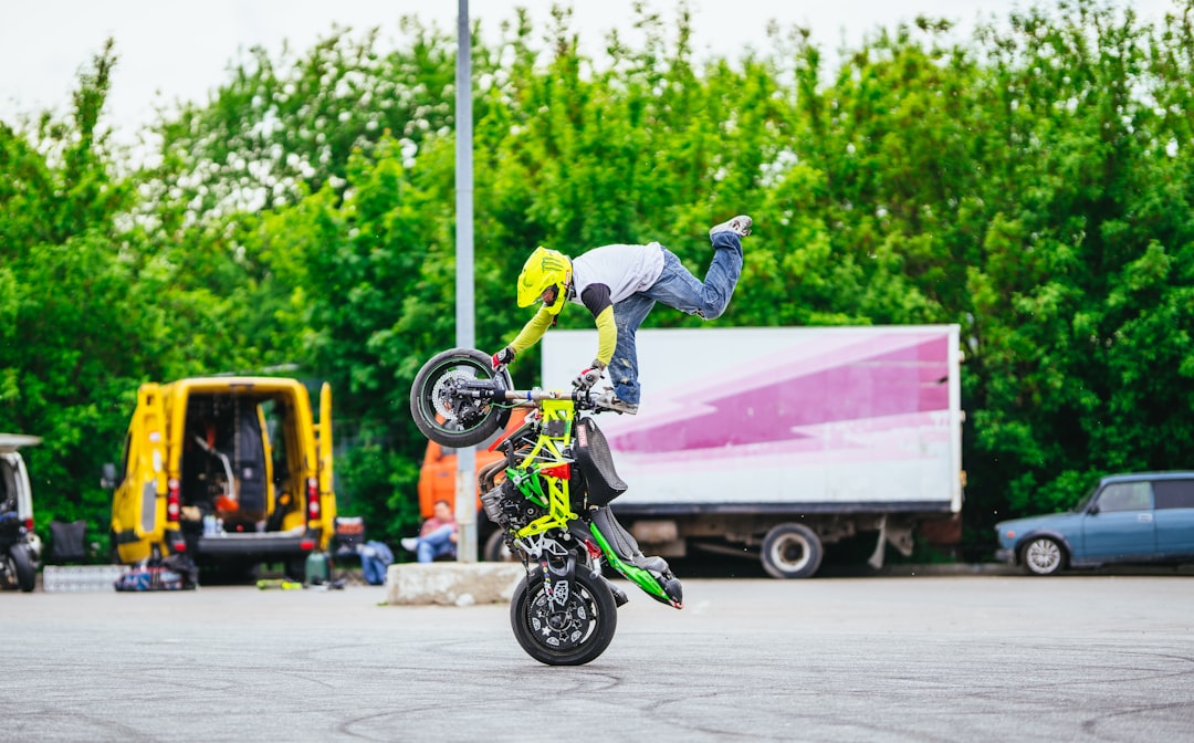 man riding motorcycle at daytime bmx tricks, freestyle riding, urban setting