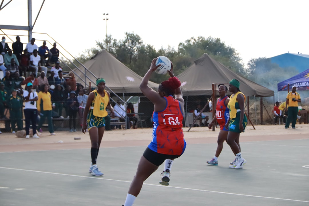 Netball players compete on a court. nbl court, tip off, players in motion