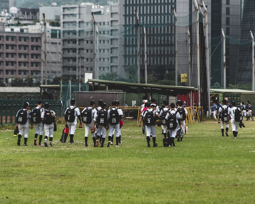 people in black and white uniform on green grass field during daytime flag football kids girls competition team huddle