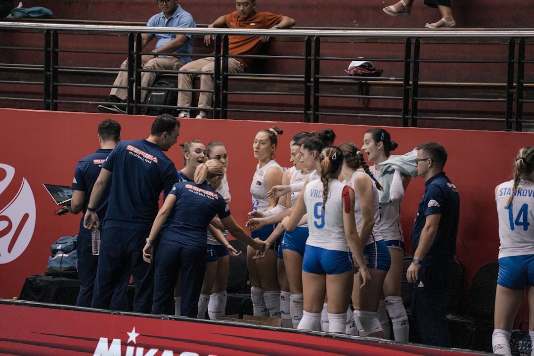 Volleyball team huddles during a game break. volleyball injury substitution bench players
