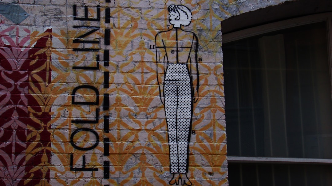 A building with a sign painted on the side of it post malone style,fashion courtside,nba culture,mural tribute