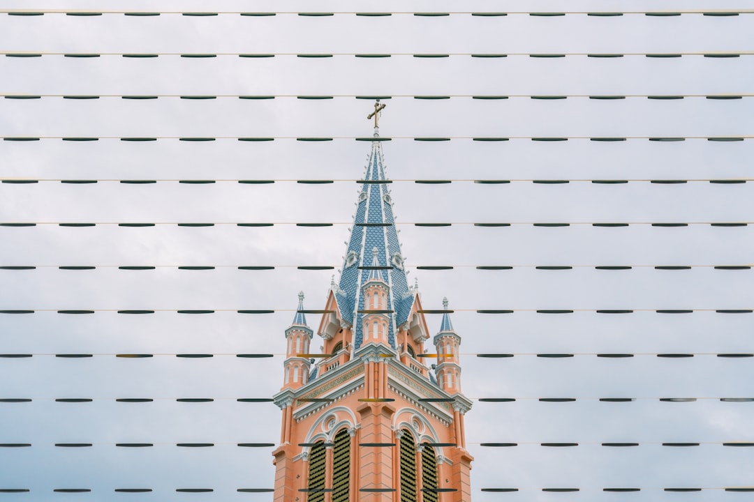 A church steeple rises against a cloudy sky. church website, religious theme, wordpress design